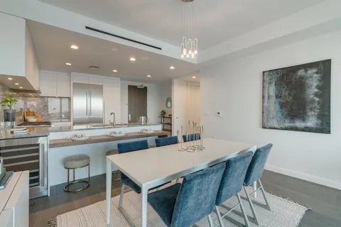 a kitchen with a dining table chairs stainless steel appliances and cabinets