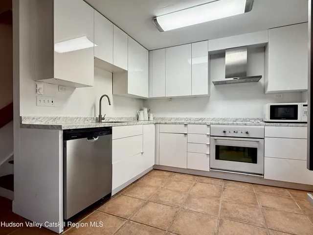 a kitchen with white cabinets and white appliances