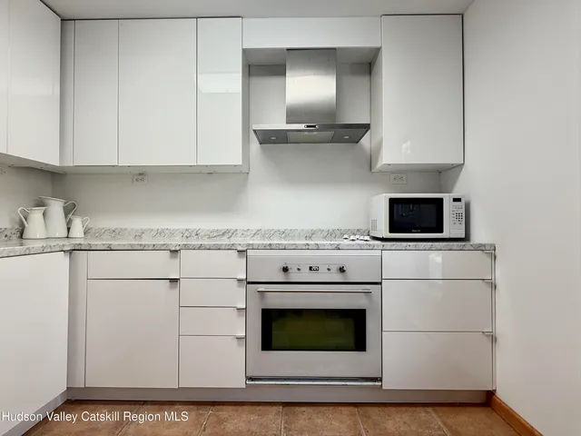 a kitchen with granite countertop white cabinets and white appliances
