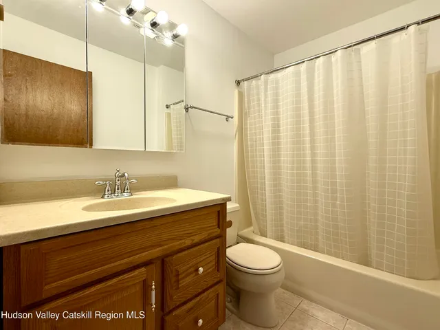 a view of an empty room with wooden floor and windows