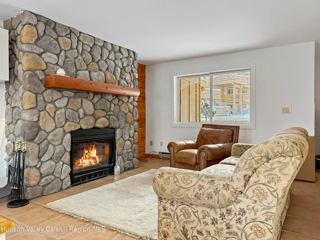 a view of a livingroom with a fireplace and a kitchen