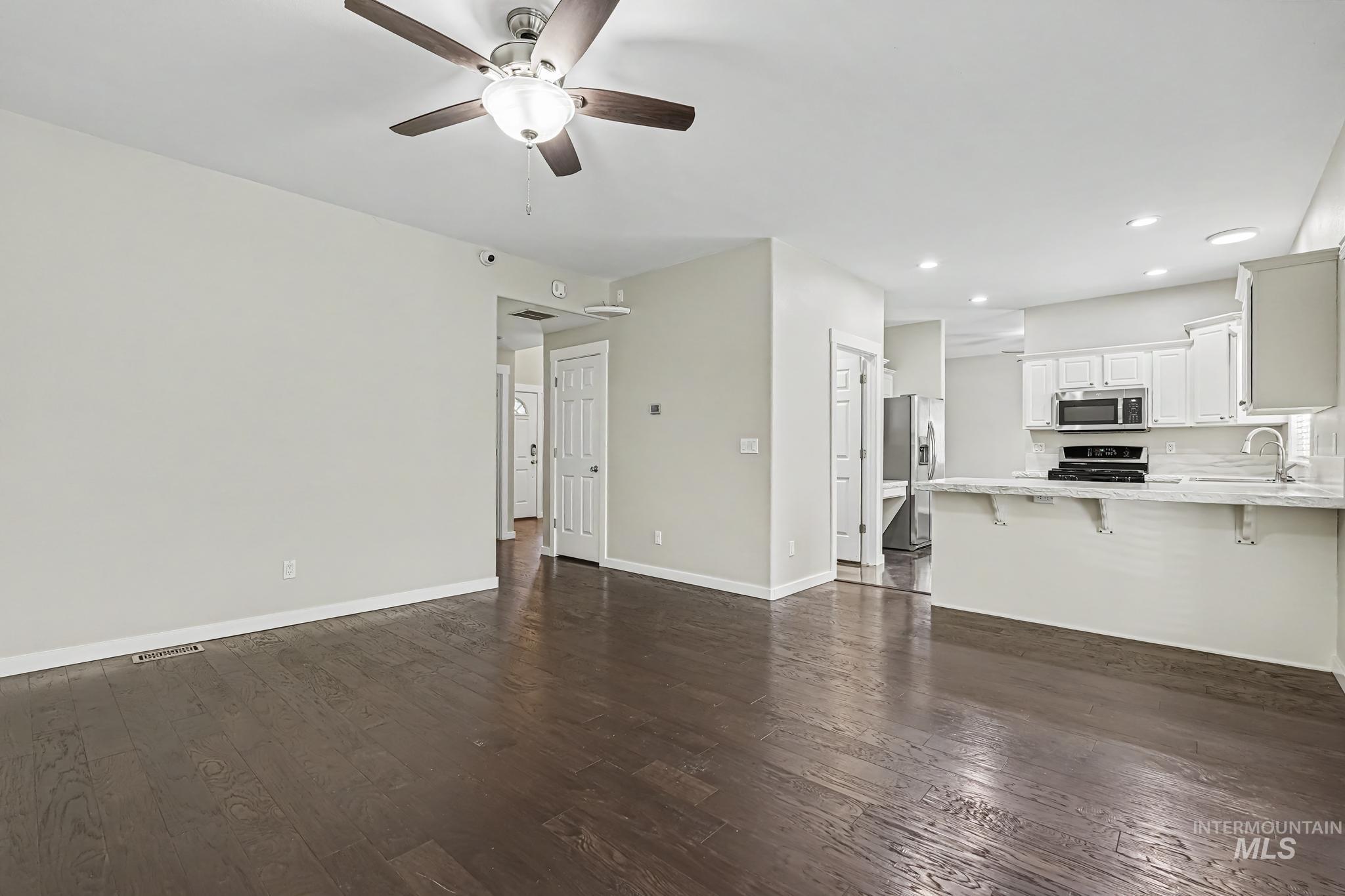 14421 West Stockwell Street Boise, ID 83713 - Photo 4 of 20 Spacious room featuring dark wood-finish flooring, a ceiling fan with integrated lighting, recessed lighting, and light-toned wall paint