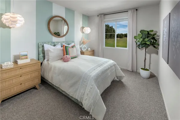 a bedroom with bed and a potted plant