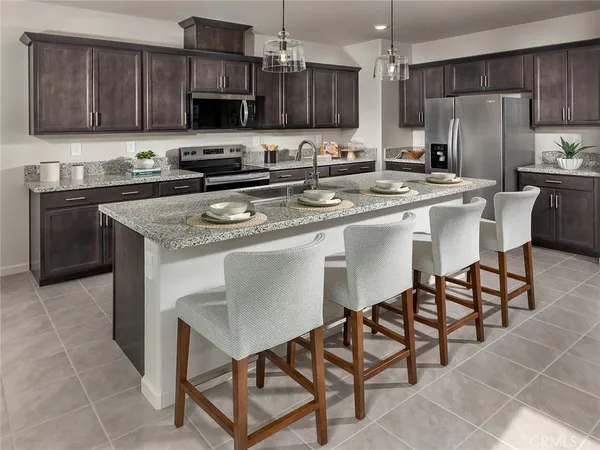 a kitchen with stainless steel appliances granite countertop a sink a stove a microwave a refrigerator and cabinets