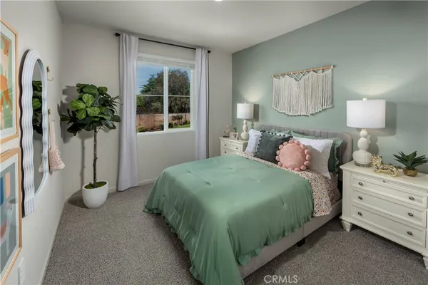 a bedroom with a bed and a potted plant