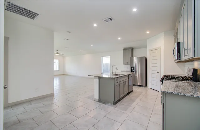 a kitchen with a refrigerator and a stove top oven