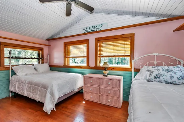 a bedroom with a bed and a chair with the wooden floor