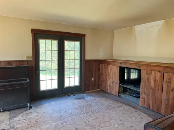 a view of an empty room with a fireplace and a window