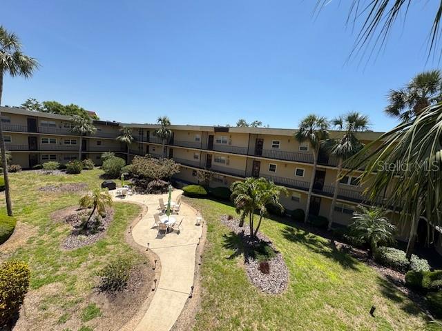 11485 Oakhurst Road, Unit 319 Largo, FL 33774 - Photo 32 of 63 a view of a backyard with couches under an umbrella