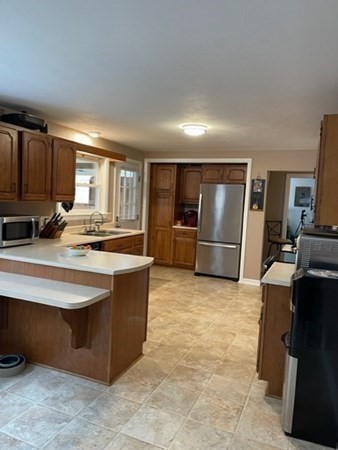 5 Kitchener Road Sterling, MA 01564 - Photo 19 of 29 a view of kitchen with kitchen island granite countertop a refrigerator cabinets and wooden floor