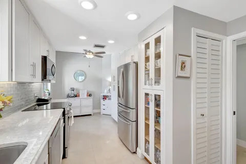 a kitchen with granite countertop a stove top oven sink and cabinets