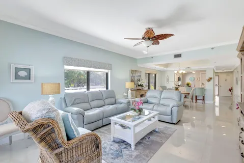 a living room with furniture a flat screen tv and a chandelier