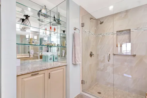 a bathroom with a granite countertop sink a large mirror and shower