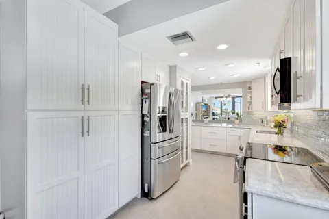 a kitchen with stainless steel appliances granite countertop a refrigerator and a sink