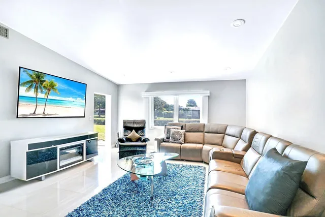 a living room with furniture a fireplace and a large window