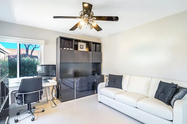 a living room with furniture kitchen view and a large window