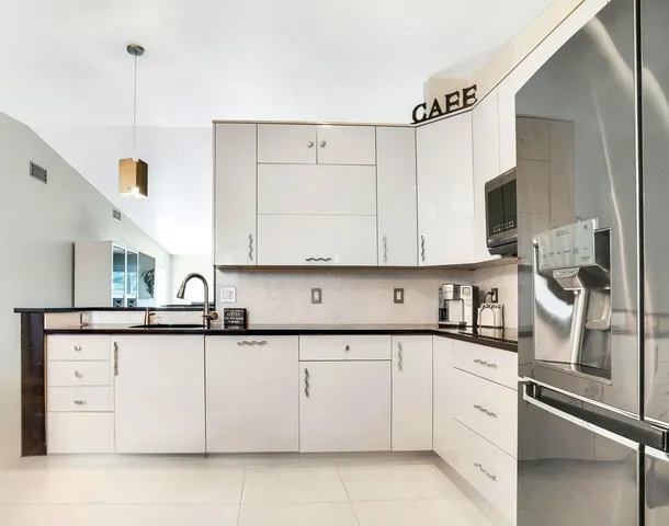 a kitchen with stainless steel appliances granite countertop a sink a stove and cabinets