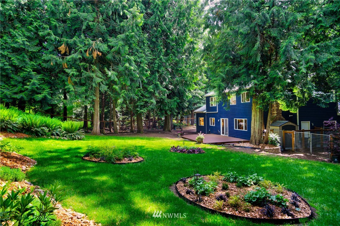 1230 Cedar Circle Langley, WA 98260 - Photo 26 of 39 a backyard of a house with table and chairs plants and large tree