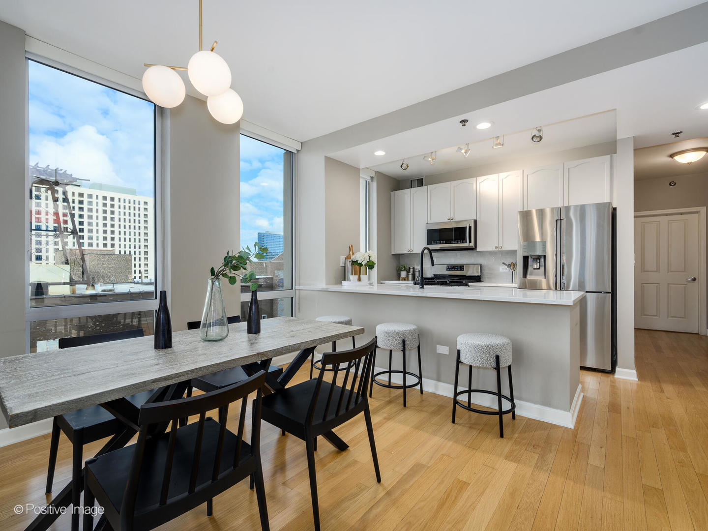 1250 South Michigan Avenue, Unit 910 Chicago, IL 60605 - Photo 7 of 26 a kitchen with stainless steel appliances a dining table chairs stove refrigerator and cabinets