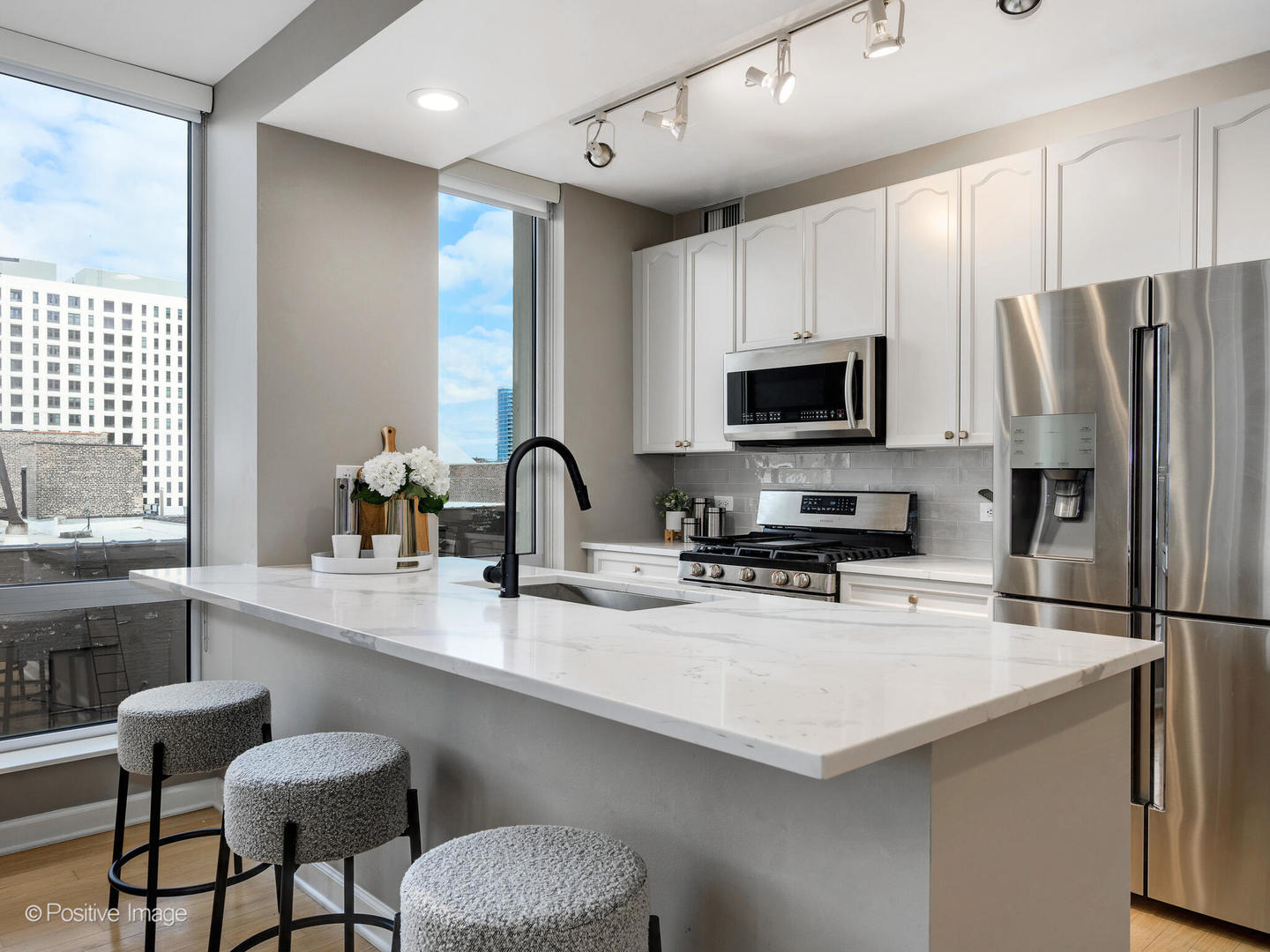1250 South Michigan Avenue, Unit 910 Chicago, IL 60605 - Photo 8 of 26 a kitchen with stainless steel appliances a stove refrigerator sink and microwave