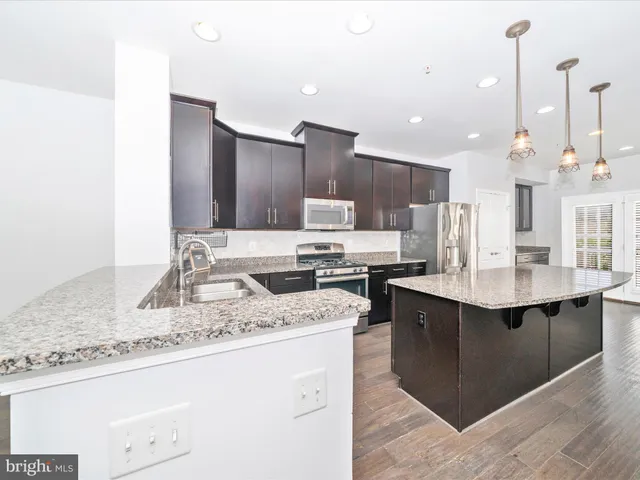 a kitchen with granite countertop stainless steel appliances and wooden cabinets