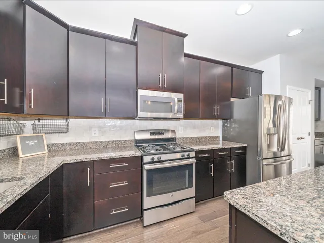 a kitchen with stainless steel appliances granite countertop a sink stove and cabinets