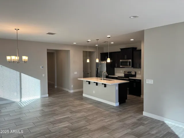 a large white kitchen with a large counter top space and stainless steel appliances
