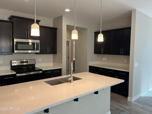 a kitchen with a sink a microwave a stove and refrigerator