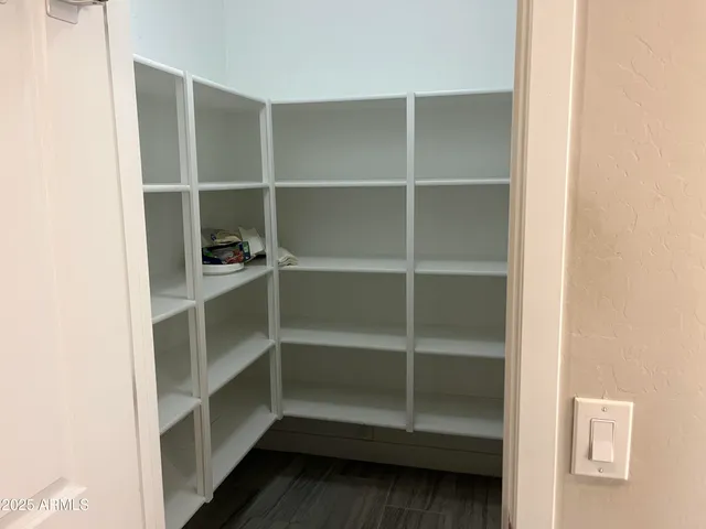 a view of walk in closet with empty racks