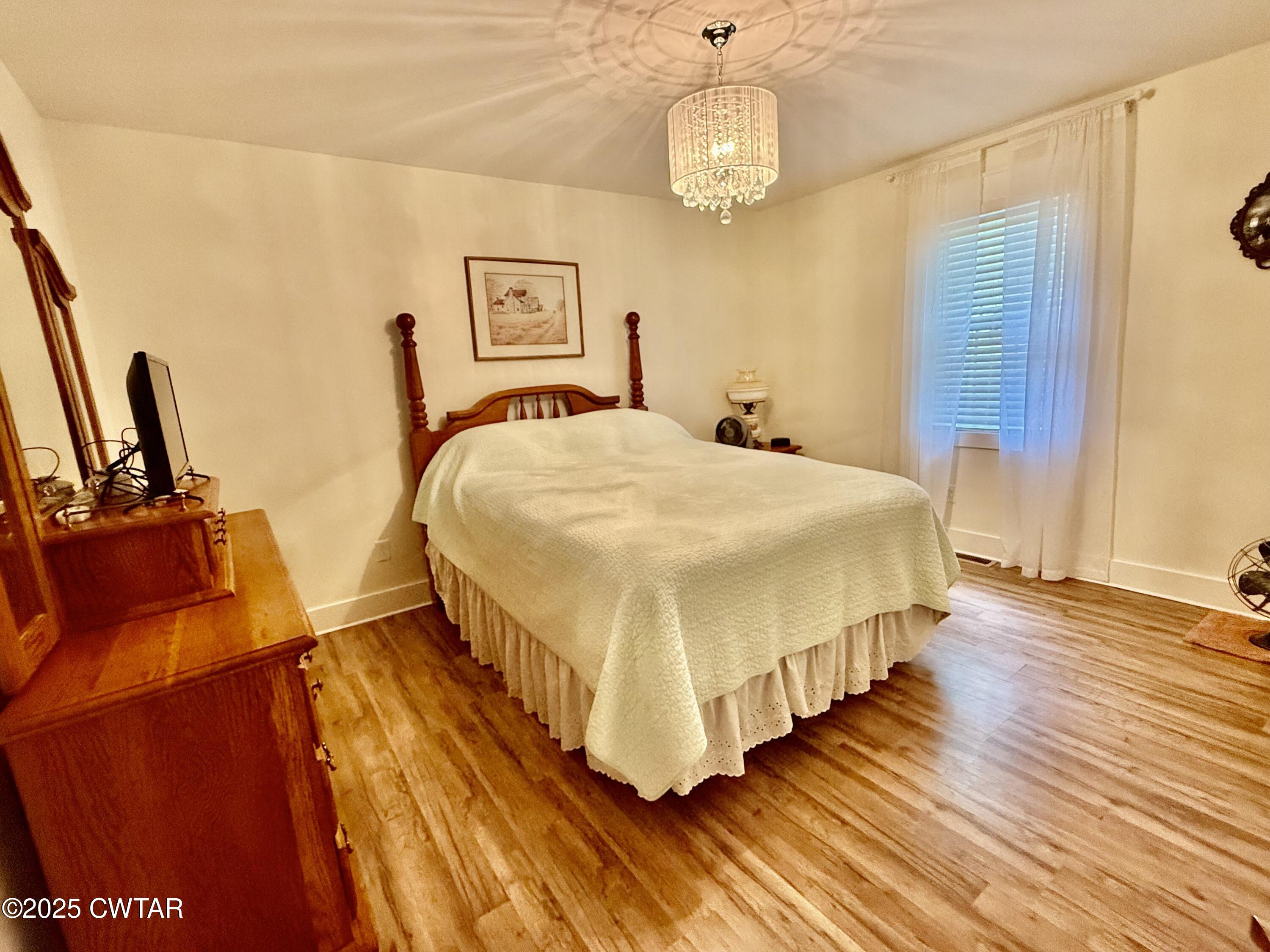 4815 Webb Store Road Hornbeak, TN 38232 - Photo 12 of 23 a spacious bedroom with a bed and wooden floor