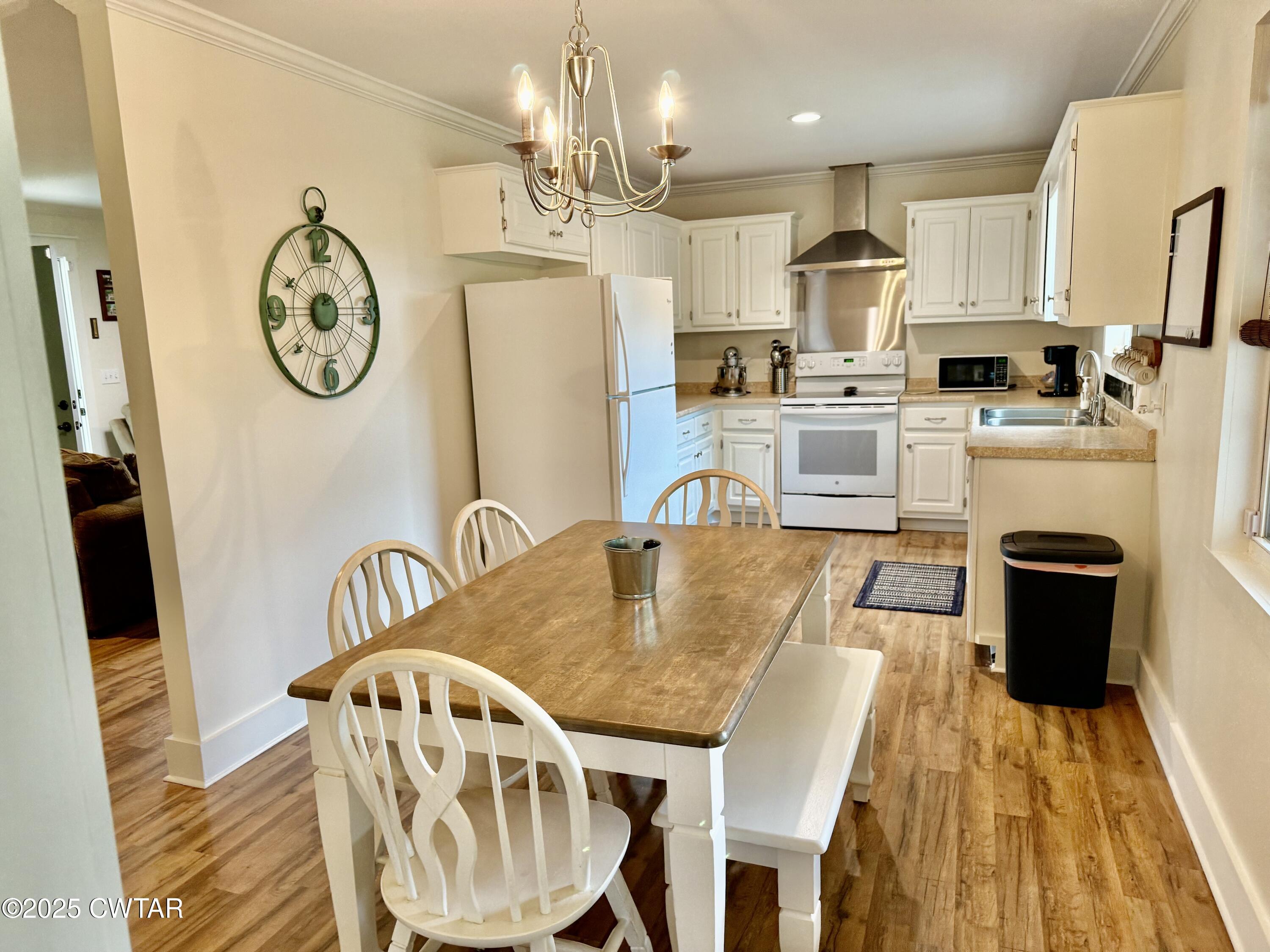 4815 Webb Store Road Hornbeak, TN 38232 - Photo 9 of 23 a large kitchen with stainless steel appliances granite countertop a dining table chairs and a refrigerator