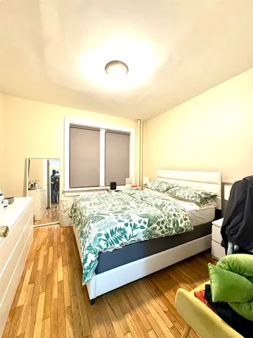 a bed sitting in a bedroom next to a larger window