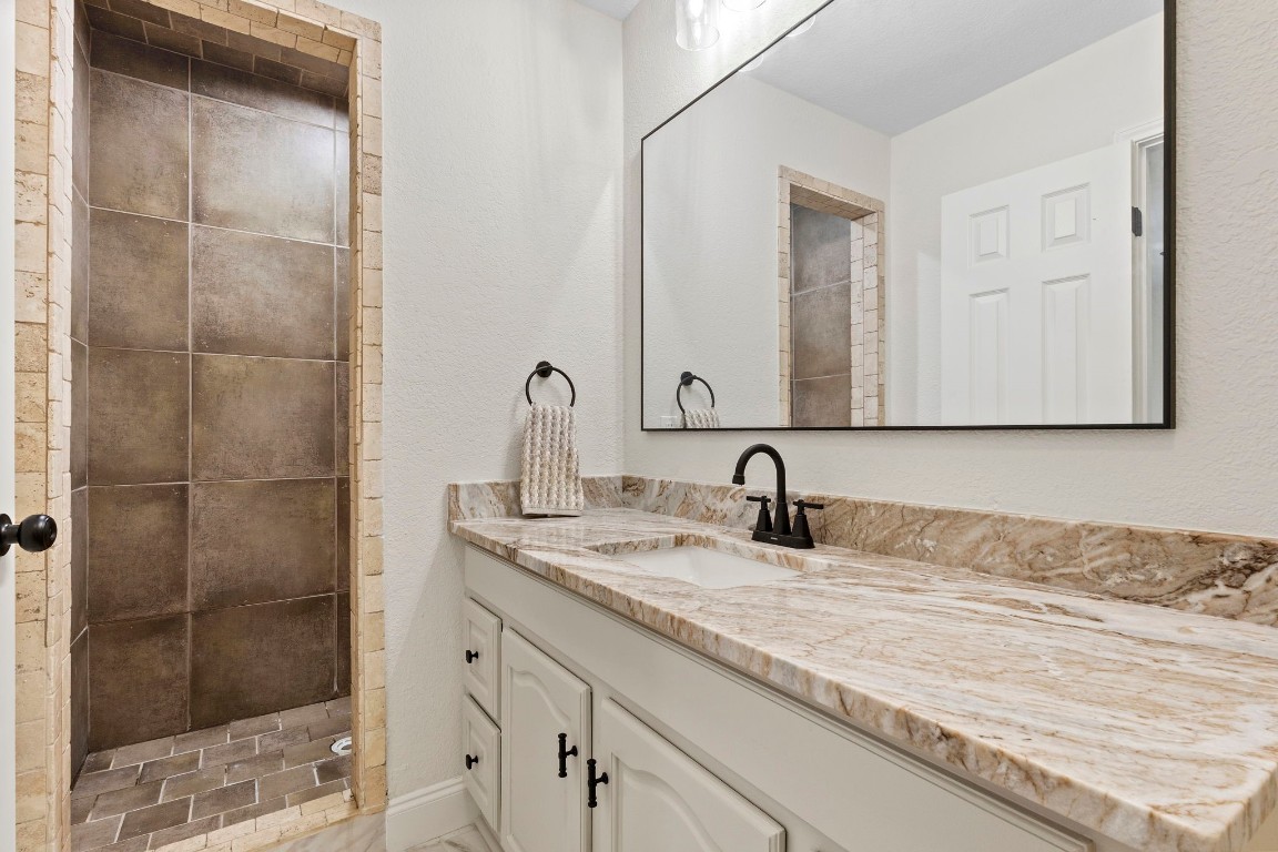 135 James Street Bridge City, TX 77611 - Photo 7 of 12 a bathroom with a granite countertop sink a mirror and shower