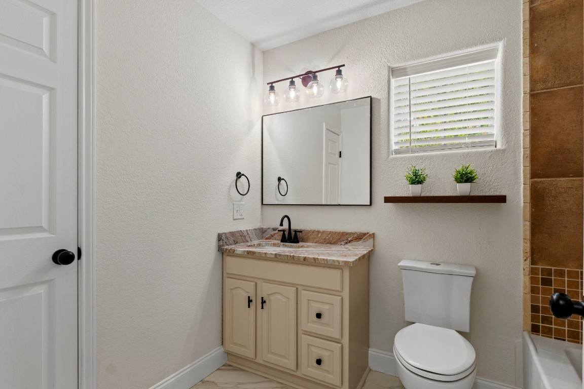 135 James Street Bridge City, TX 77611 - Photo 9 of 12 a bathroom with a granite countertop toilet sink and mirror