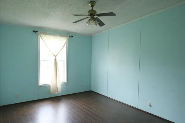 an empty room with a window and a ceiling fan