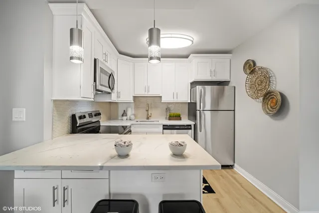 a kitchen with stainless steel appliances granite countertop a sink a refrigerator and a stove