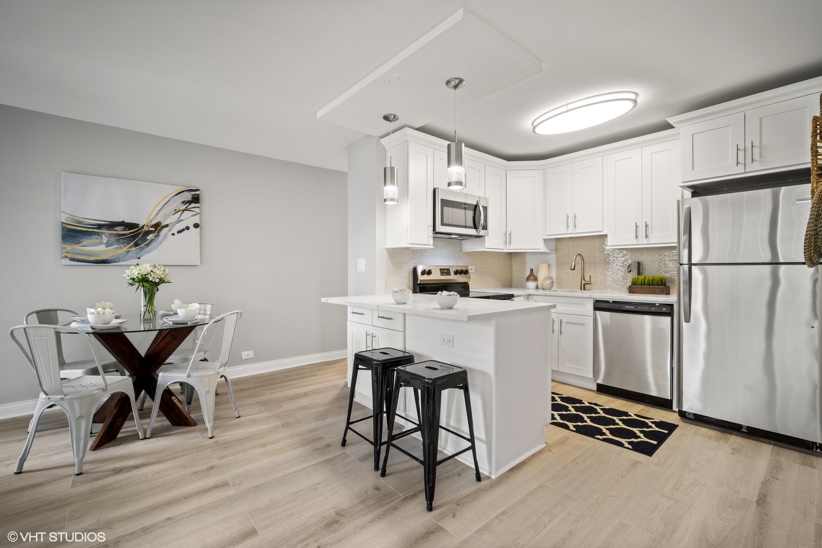 33 East Cedar Street, Unit 8H Chicago, IL 60611 - Photo 5 of 17 a kitchen with a refrigerator a white cabinets and chairs