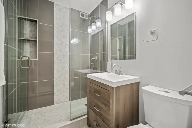 a bathroom with a sink a toilet and shower