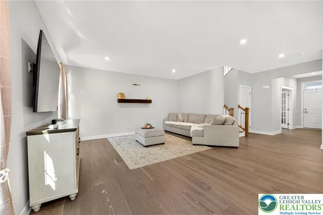 a kitchen with stainless steel appliances granite countertop a stove a refrigerator a kitchen island a dining table and chairs with wooden floor