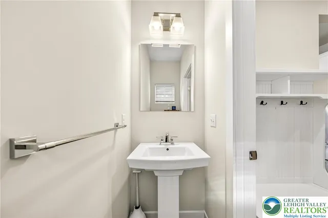 a bathroom with a sink a vanity a mirror and a bathtub next to a window