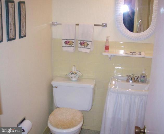 1499 Kimblewick Road Potomac, MD 20854 - Photo 9 of 17 a bathroom with a toilet a sink and mirror