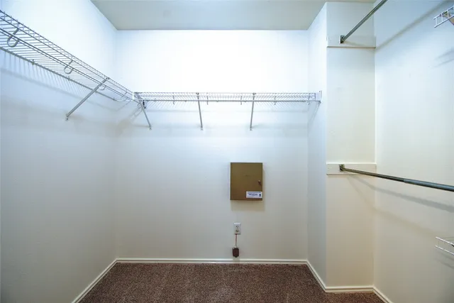 an empty room with a chandelier fan and windows