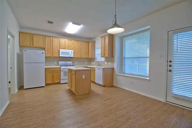 a kitchen with stainless steel appliances granite countertop a stove a sink dishwasher and a refrigerator
