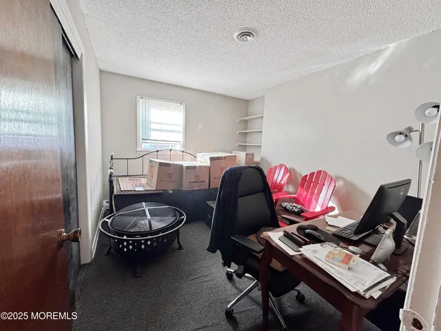 a view of a workspace with furniture and a window