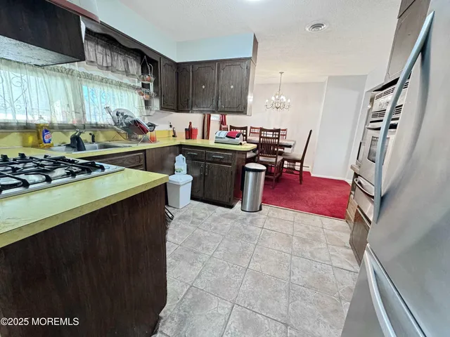 a kitchen with a sink a stove and chairs