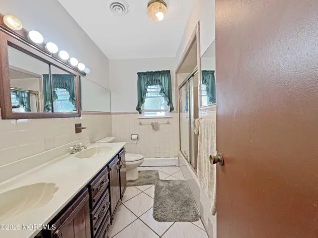a bathroom with a sink a toilet and mirror