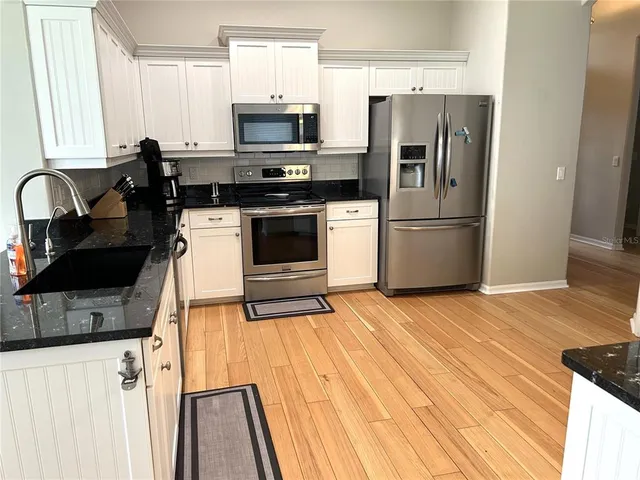 a kitchen with a sink a stove a microwave and refrigerator