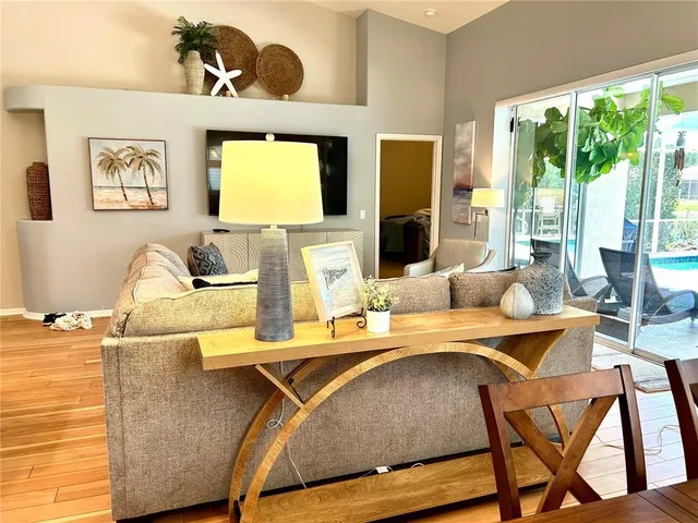 a living room with a table chairs and a open kitchen view
