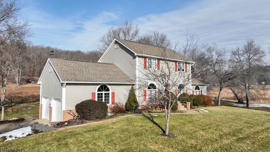 4848 Fette Road Dennison, OH 44621 - Photo 2 of 48 View of front of home featuring a front lawn, a garage, and concrete driveway