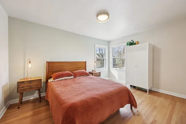 a bedroom with a bed and wooden floor